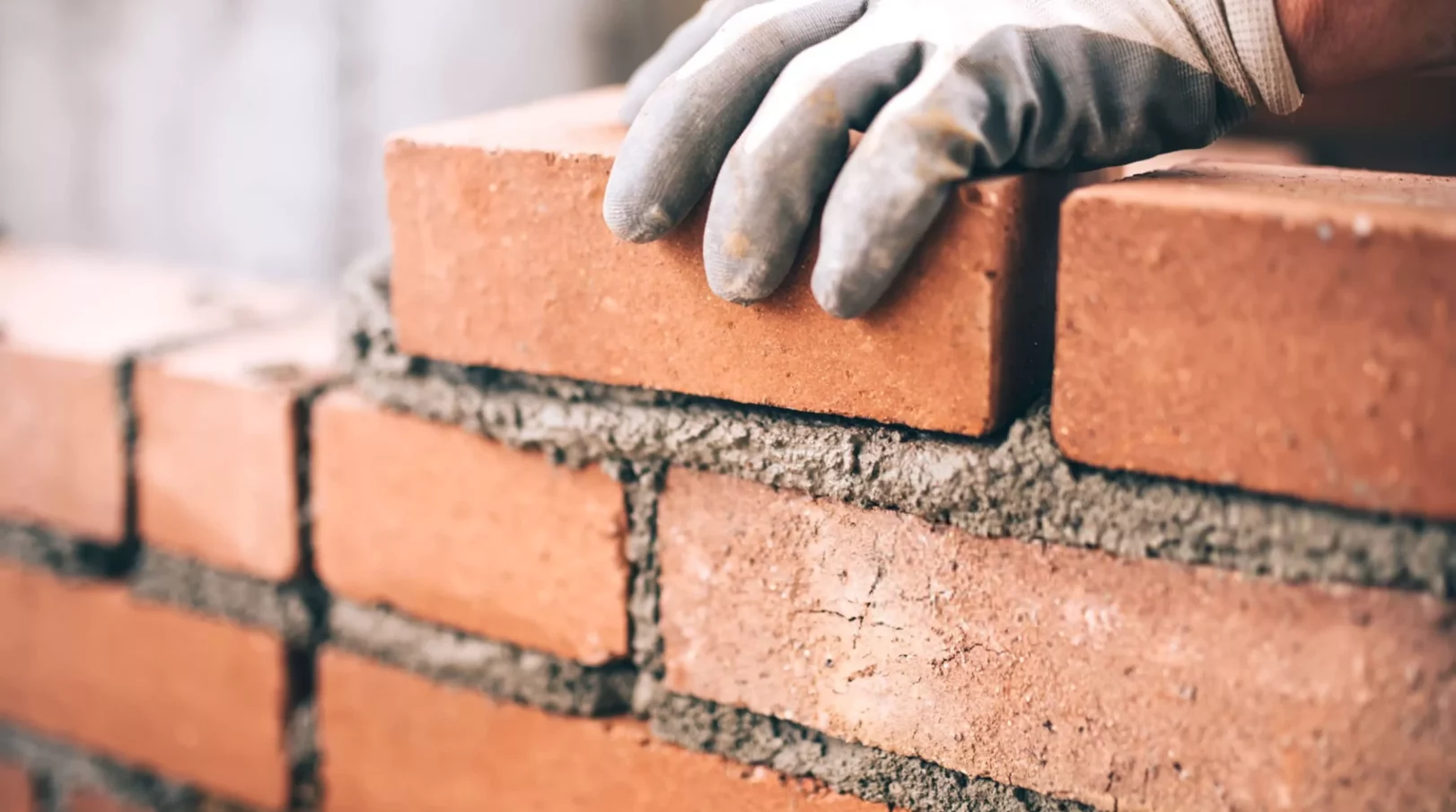 Close up of industrial bricklayer installing bricks on const-min