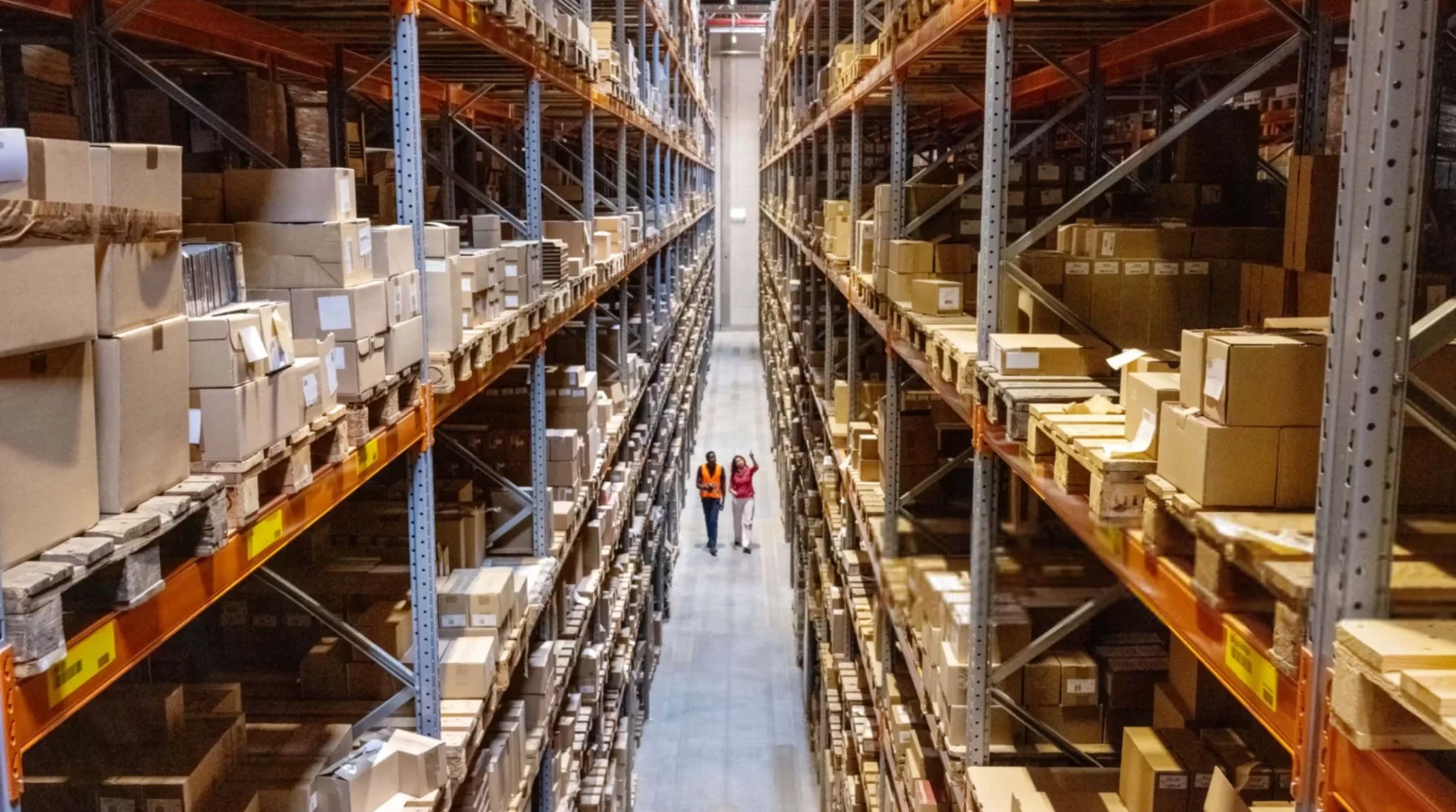 High angle view of a warehouse manager walking with foremen-min